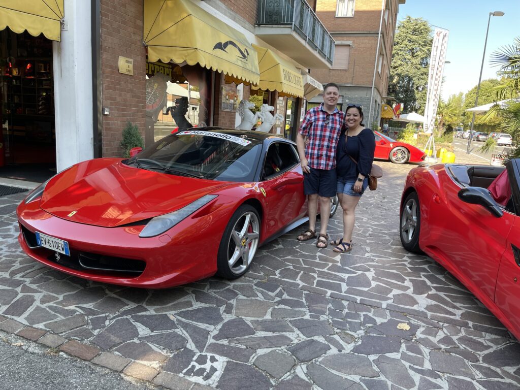 Nick and Helena at I Love Maranello Tours in front of red Ferraris